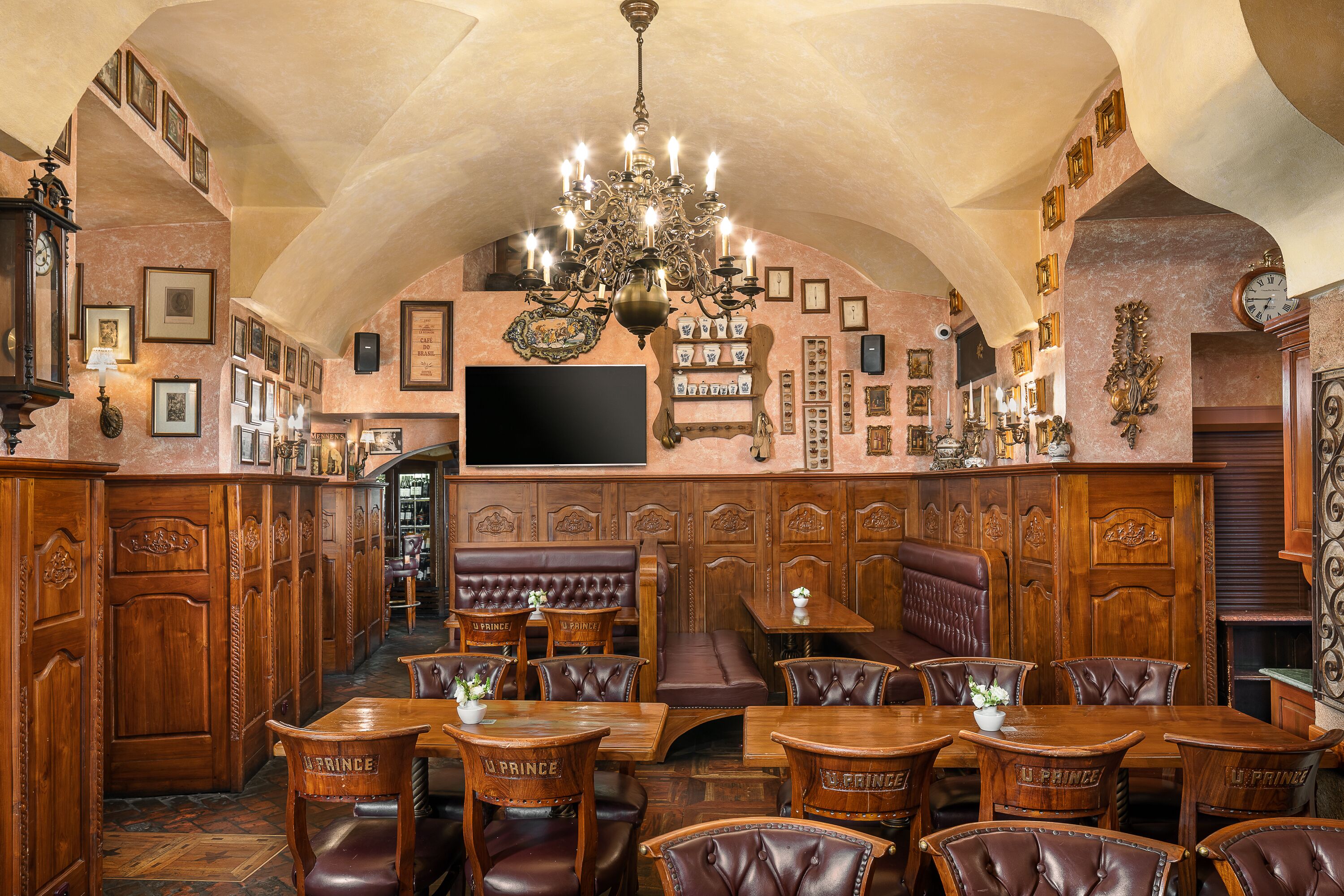 Una gran sala de dinar amb mobles de fusta, un llumí i quadres amb marc a les parets.