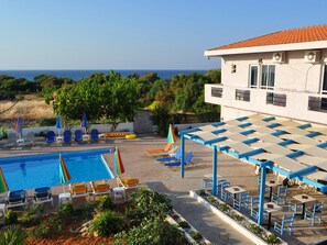 Alberca al aire libre, sombrillas en la alberca y camastros 