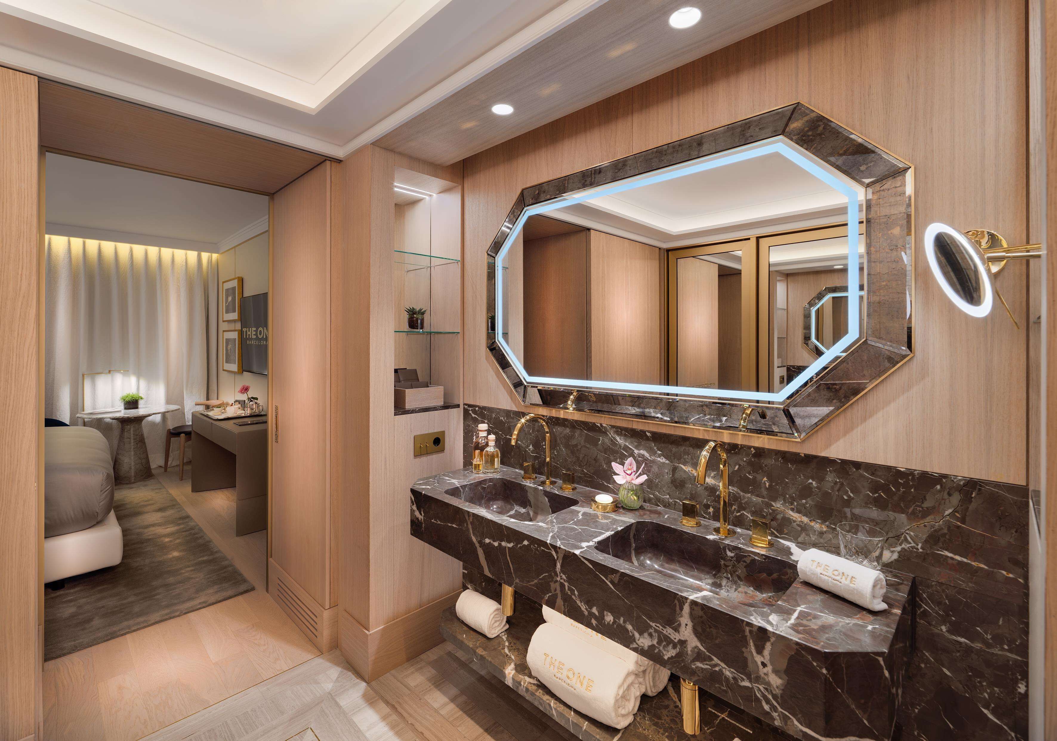 Un baño moderno con un espejo grande, lavamanos dobles y una zona de tocador.
