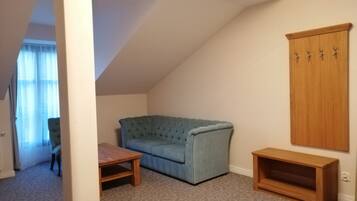 A room with a blue sofa, a wooden table, and a wooden cabinet.