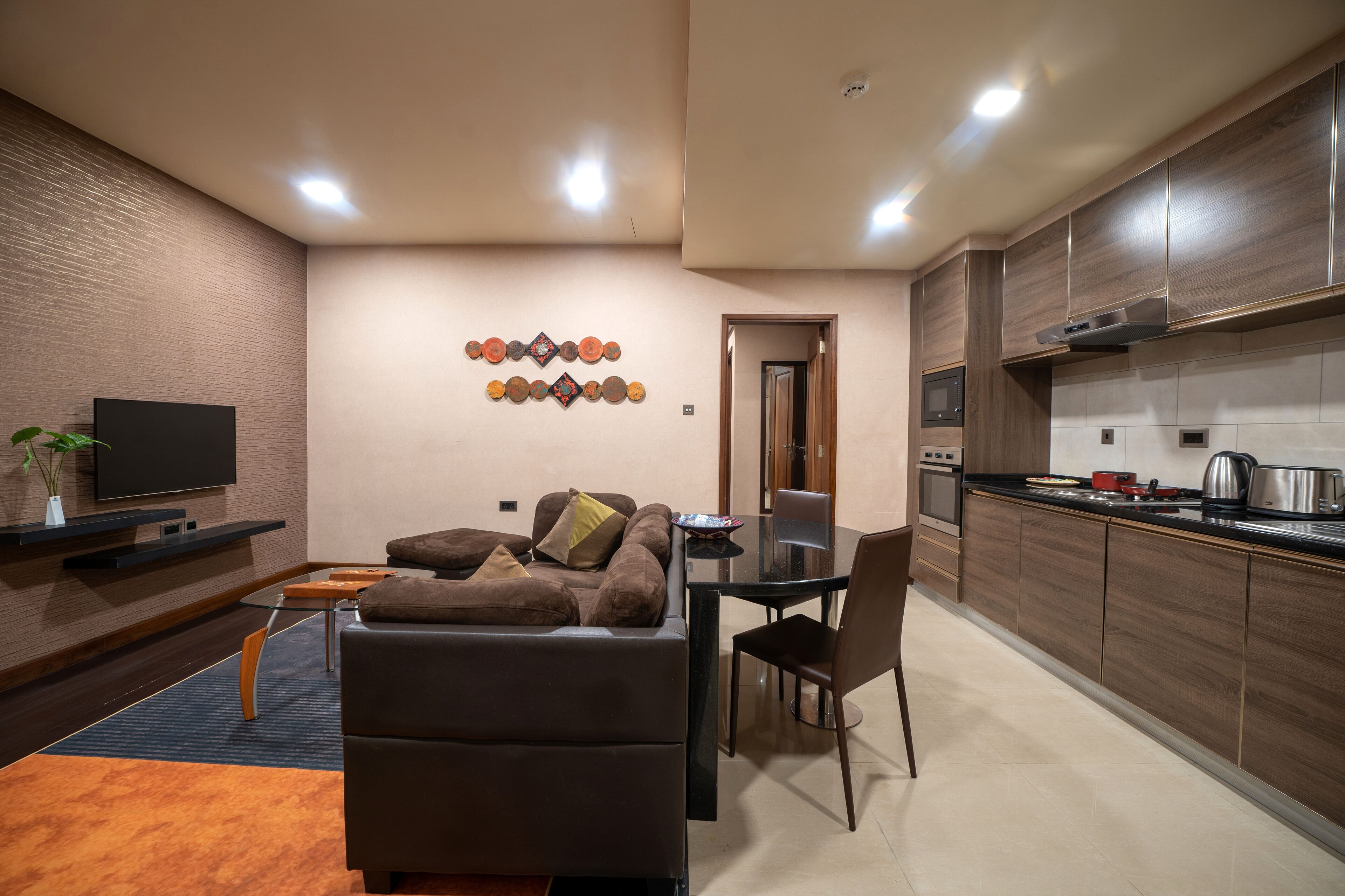 A modern living room with a sofa, TV, and decorative wall art.