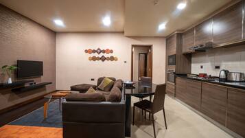 A modern living room with a sofa, TV, and decorative wall art.