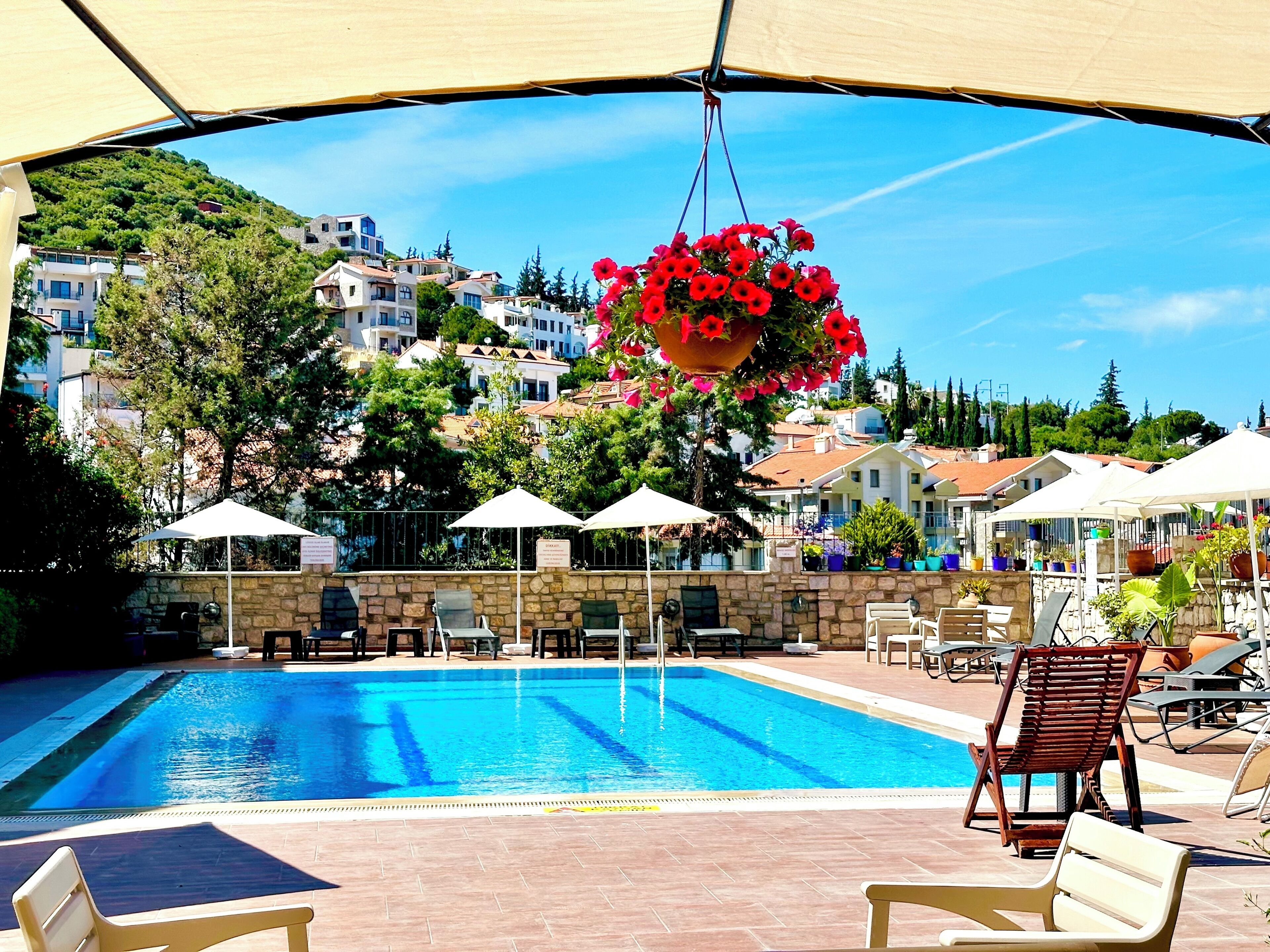 Una piscina al aire libre de temporada, sombrillas