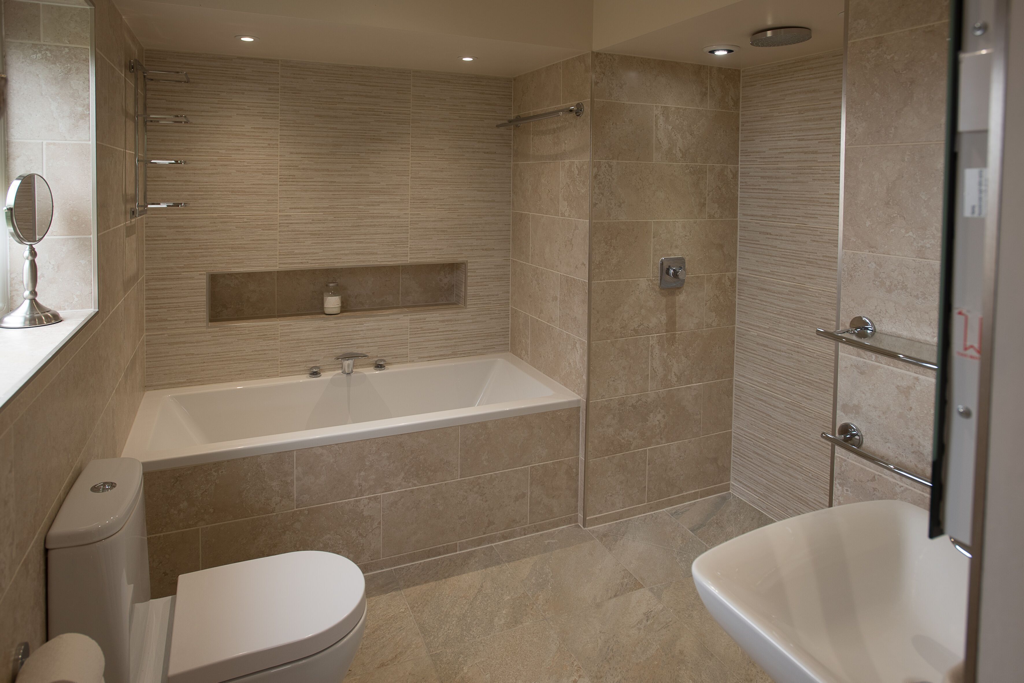 A modern bathroom with a bathtub, toilet, and shower area.