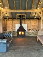 Una habitación acogedora con chimenea, paredes de madera y un marco de piedra para la chimenea.