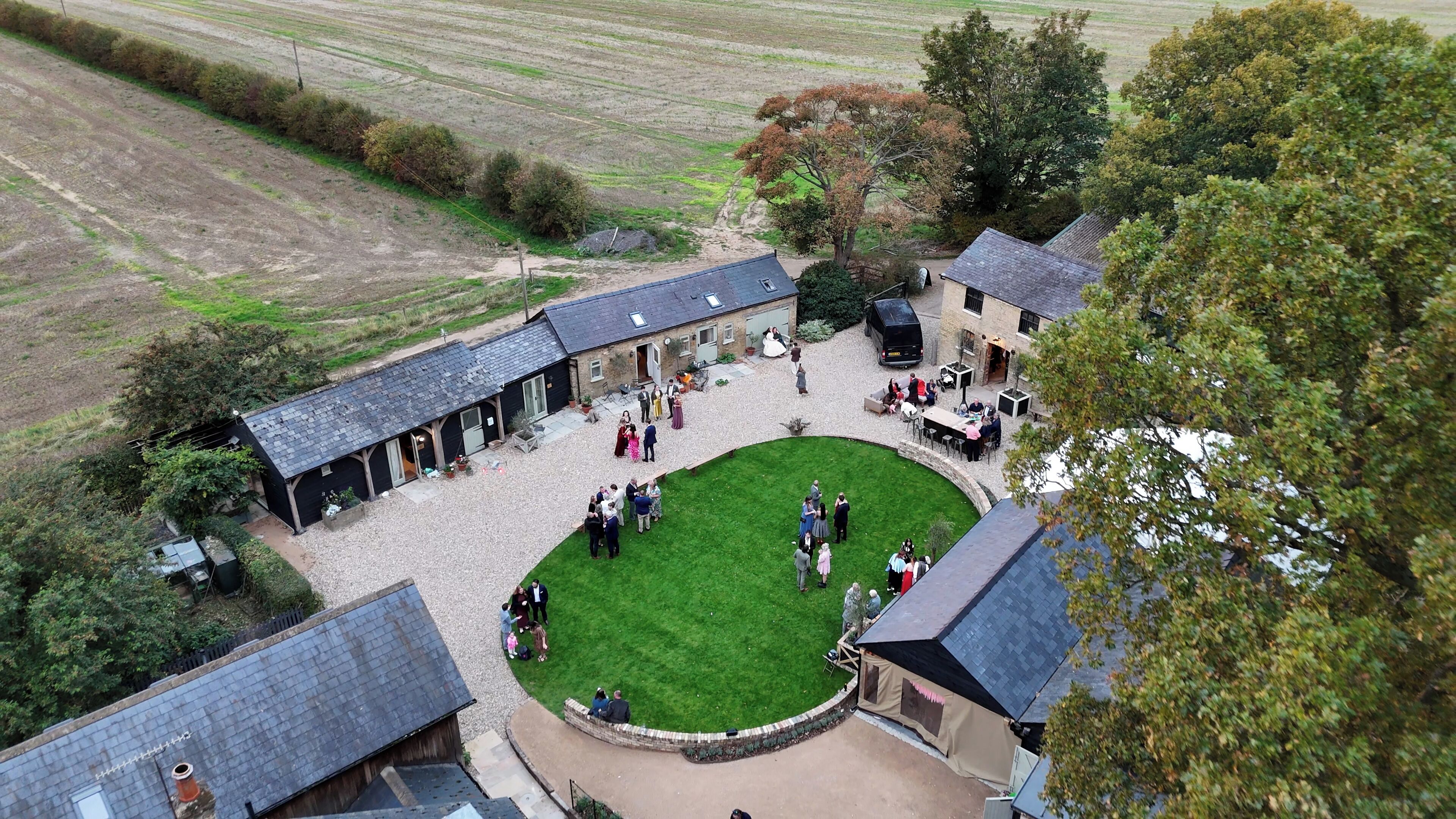 A courtyard with a central lawn surrounded by buildings, a paved walkway, and a small garden area.