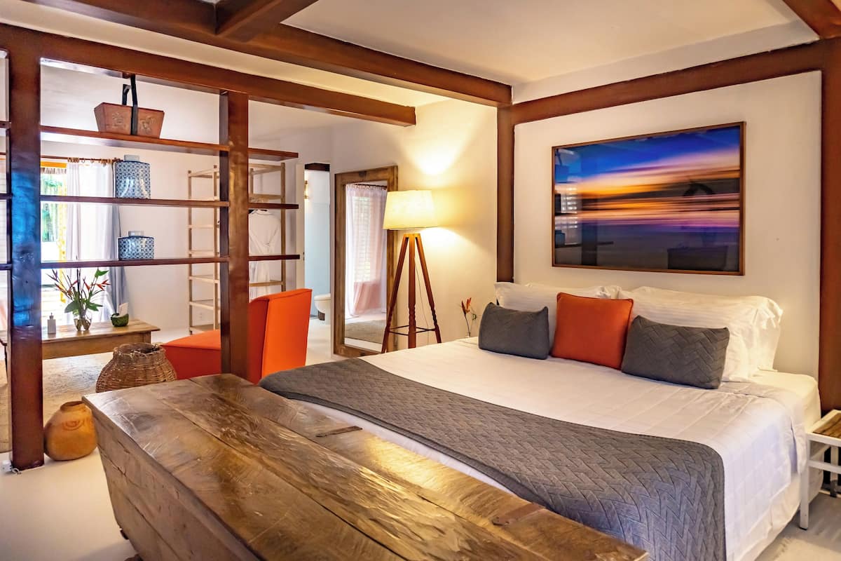 Una camera da letto con un letto grande, una panca in legno, una libreria e un quadro appeso al muro.