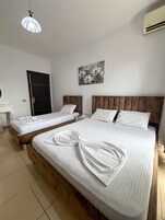 Habitación triple, balcón | Caja fuerte, wifi gratis, ropa de cama