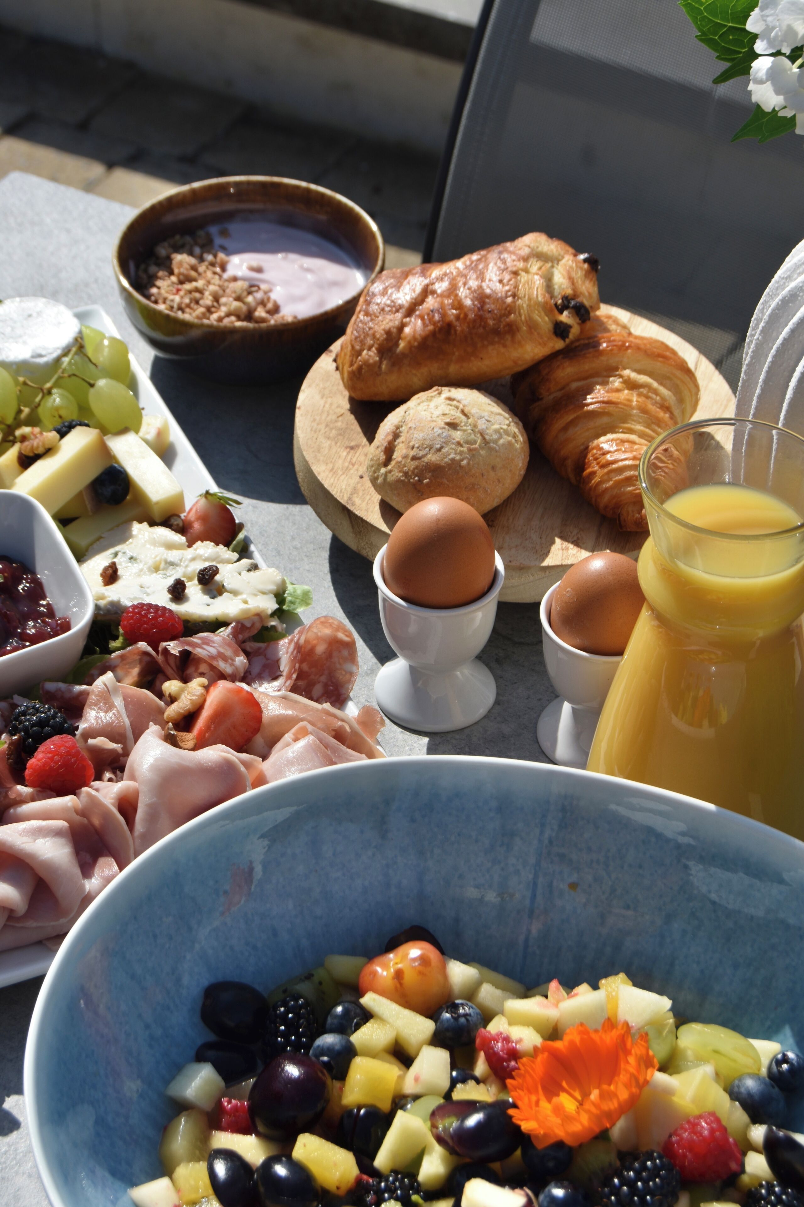 Un bufé de desayuno con diversos alimentos y un vaso de jugo de naranja.