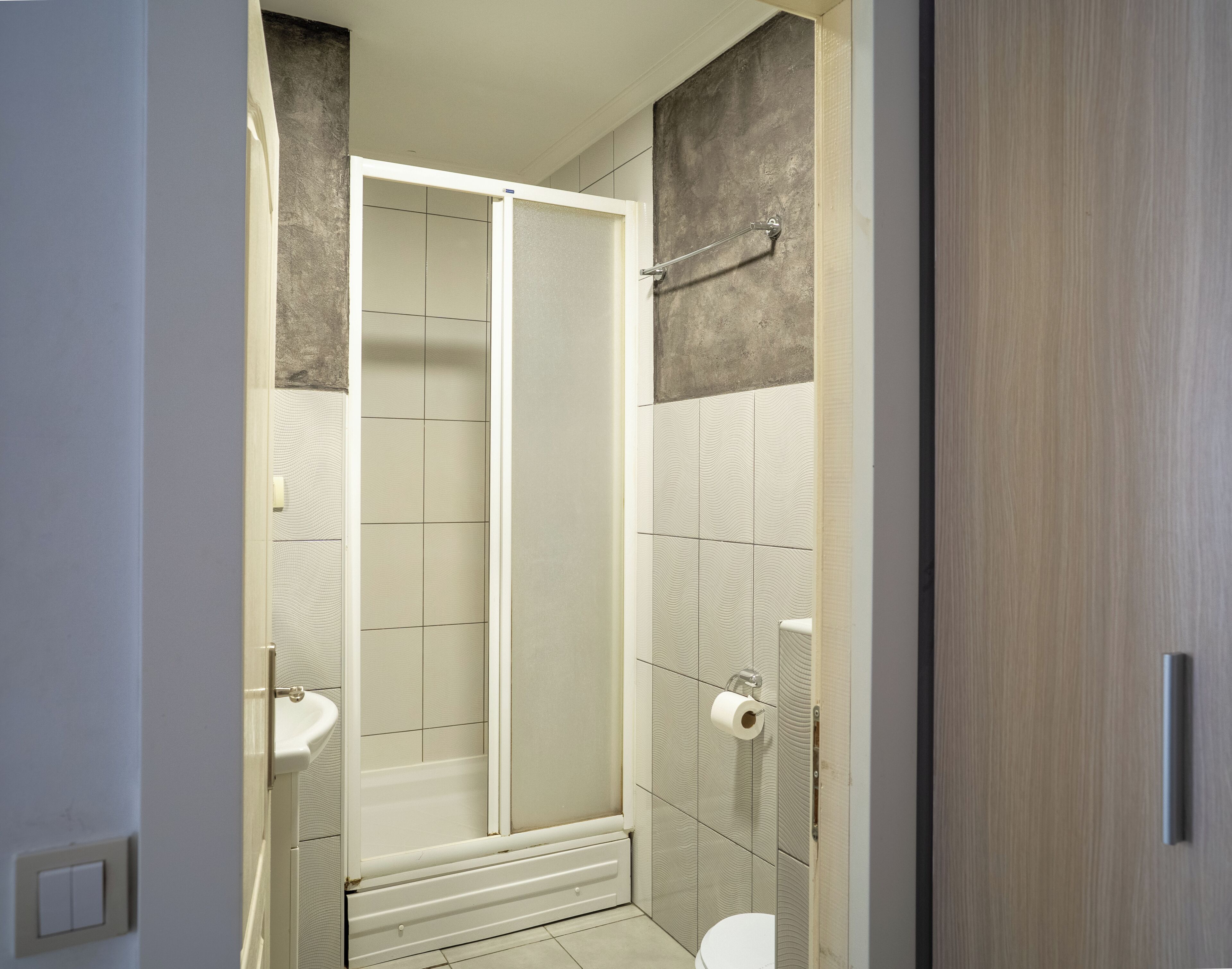 A bathroom with a shower, toilet, and sink.