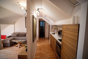 Una cocina moderna con armarios de madera, una mesa de comedor con cubierta de vidrio y un horno empotrado.