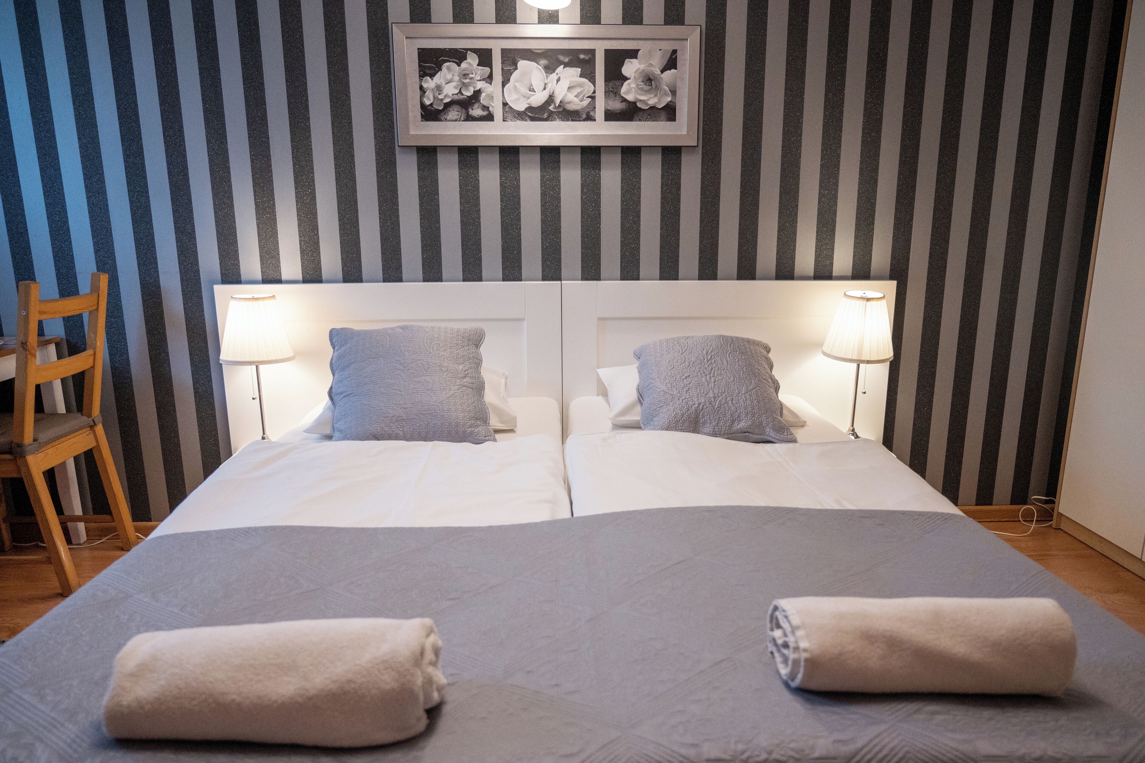 A double bed with two pillows, a headboard, and two bedside lamps.