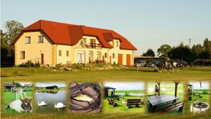 A two-story house with a red roof and a balcony. - Zajazd Agro nad Stawem (Zukowo)