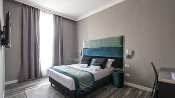 Una habitación de hotel moderna con una cama grande, cortinas grises, una pared gris y un suelo gris.