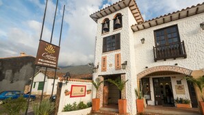 A building with a white facade, a balcony, and a sign for 'Cafeteria'. - Hotel Capitán Ricaurte (Villa de Leyva)