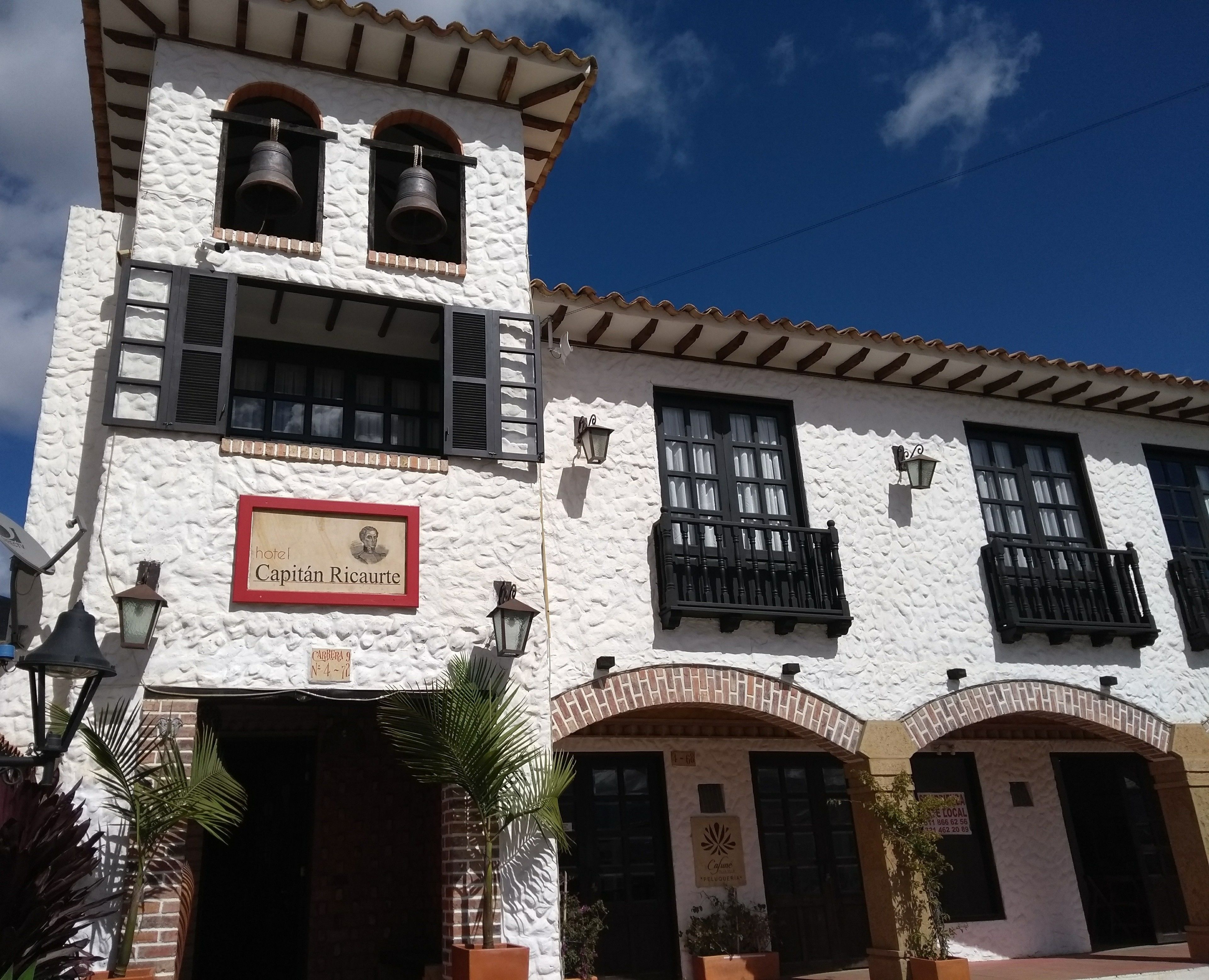 A historic building with a sign reading "Capitan Ricaurte" and a bell tower.