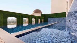 An infinity pool with a clear view of the landscape, surrounded by green walls and a tiled floor. - Ramada by Wyndham Lucknow Hotel and Convention Center (Lucknow)