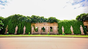A series of statues in a garden setting with a stone structure in the background. - Ramada by Wyndham Lucknow Hotel and Convention Center (Lucknow)