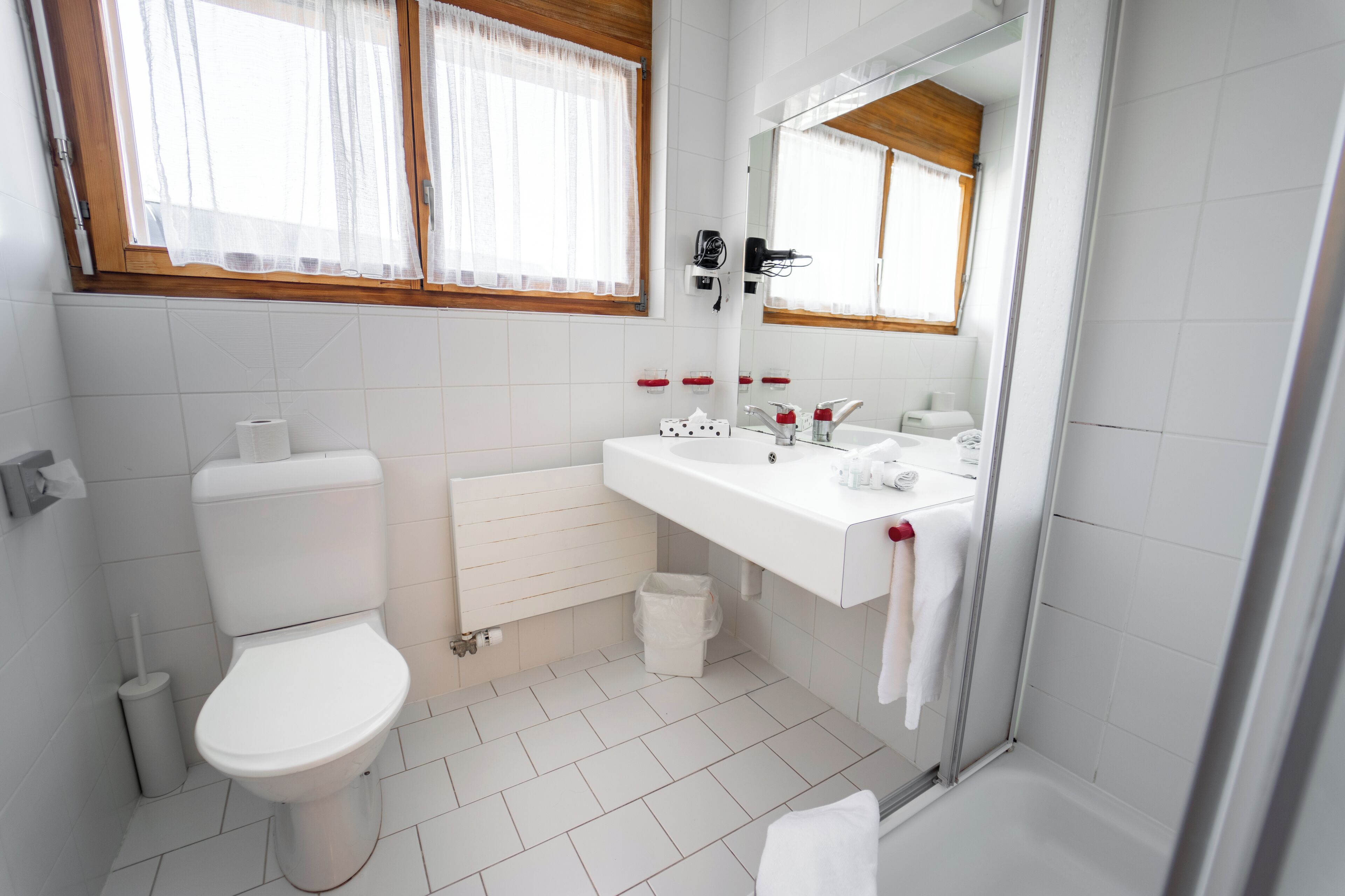 A modern bathroom with a toilet, sink, and shower.