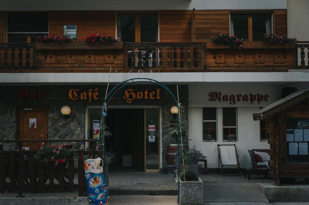 A building with a cafe, hotel, and bar signs.