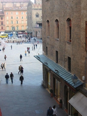 A spacious public square with a fountain, surrounded by historic buildings with arched windows and a brick facade. - Casa Isolani Piazza Maggiore 1.0 (Bologna)
