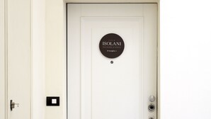 Una puerta blanca con un letrero circular que dice "ISOLANI RESIDENZE D'EPOCA D'Azeglio 1".