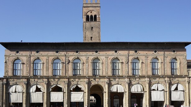 Un edificio histórico con una torre destacada y ventanas arqueadas.