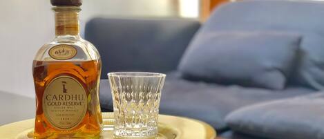 Een fles Cardhu Gold Reserve Schotse whisky en een glas op een dienblad.