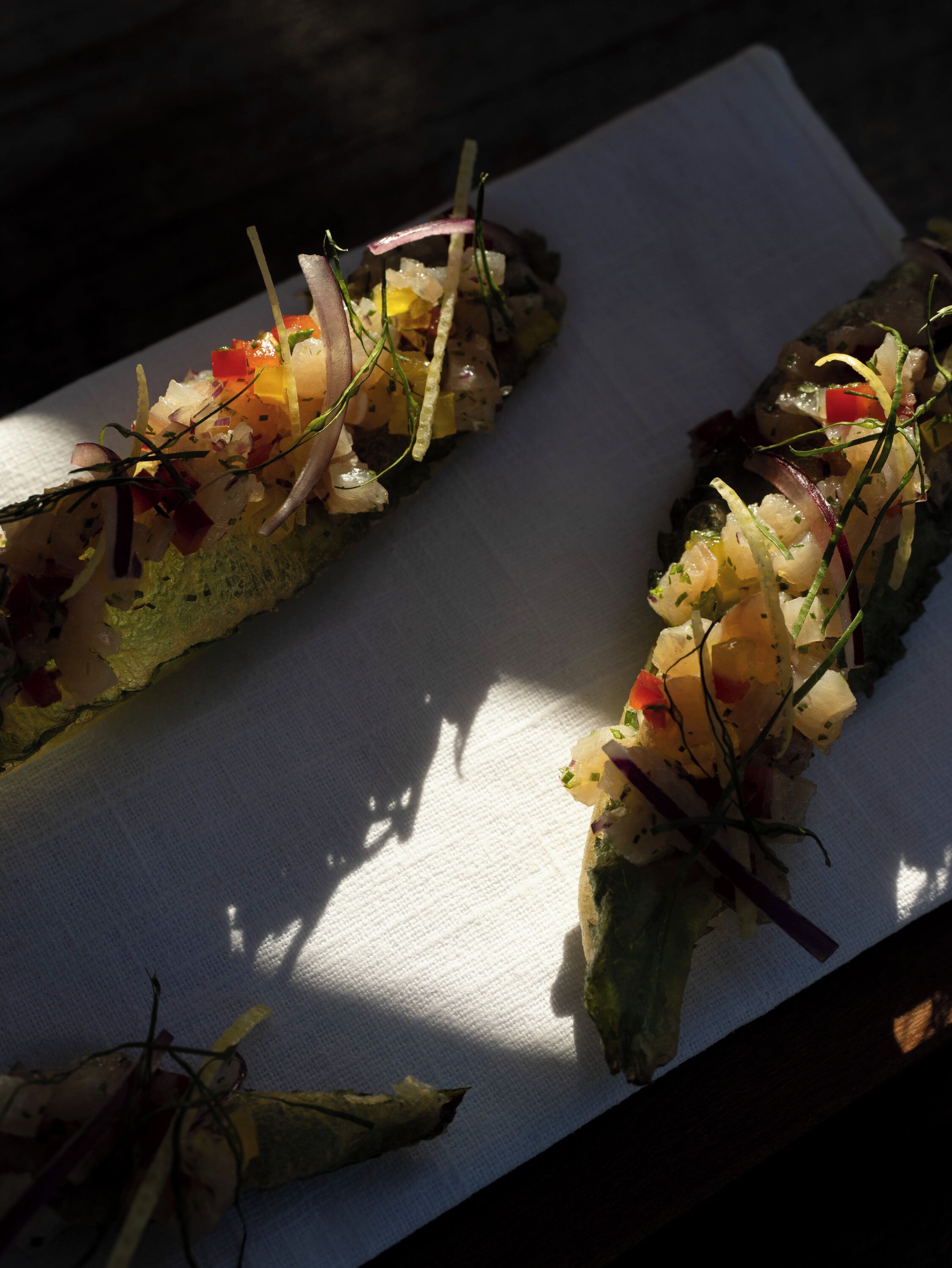 Dos rollos de sushi sobre un plato blanco con sombra.