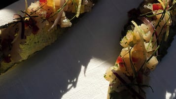 Dos rollos de sushi sobre un plato blanco con sombra.