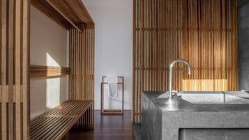 Bathroom features a large sink, bench with towel rack, and wooden slatted wall.
