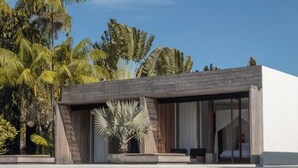 Una casa moderna con techo plano, ventanas amplias y un balcón.