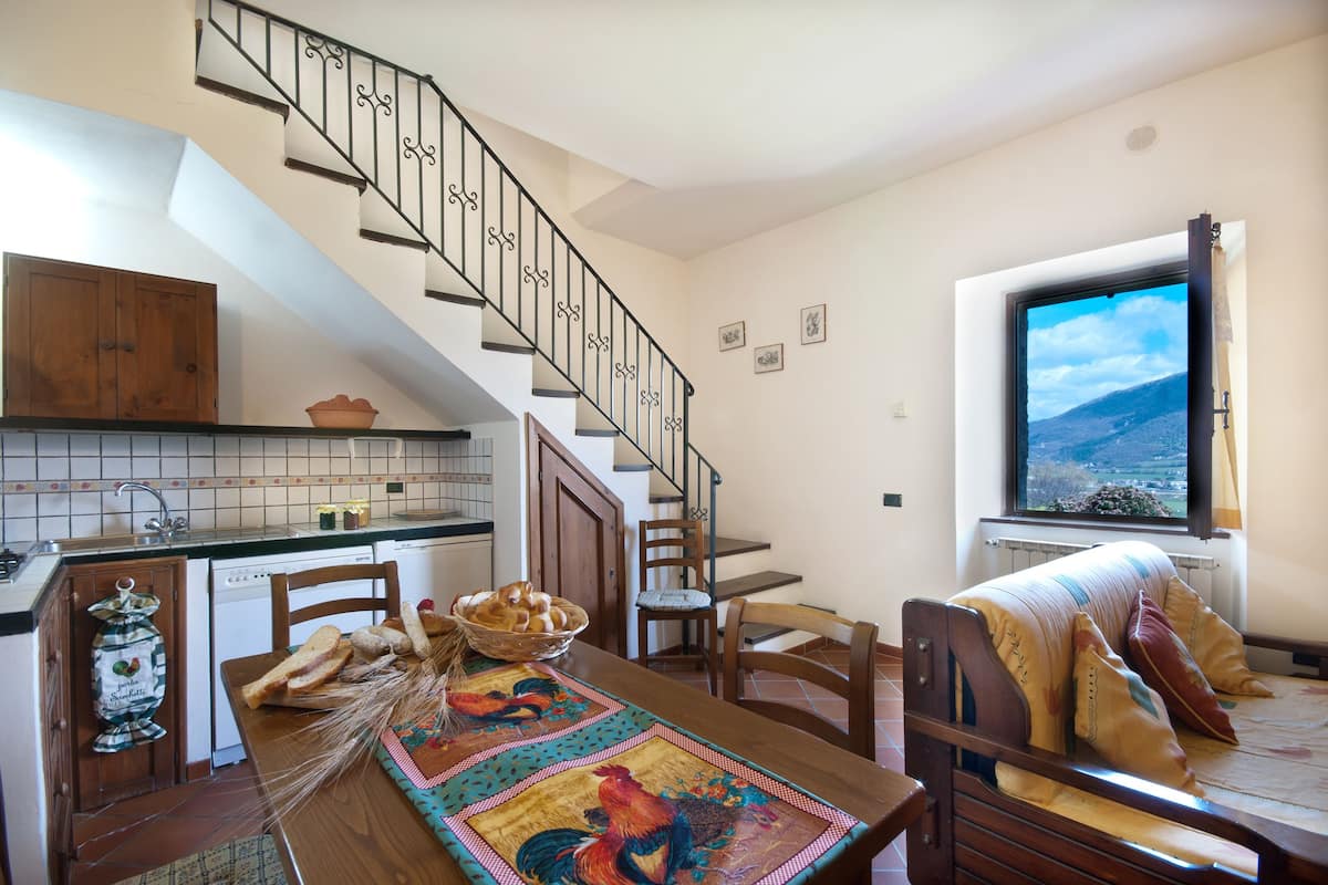 Una cocina con una mesa de madera, sillas y un comedor con vista al exterior.