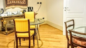 A dining area with a glass table, wooden chairs, and a patterned wall hanging. - Casa Isolani Piazza Maggiore (Bologna)