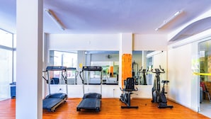 Un gimnasio con cintas de correr, elípticas y bicicletas estáticas.