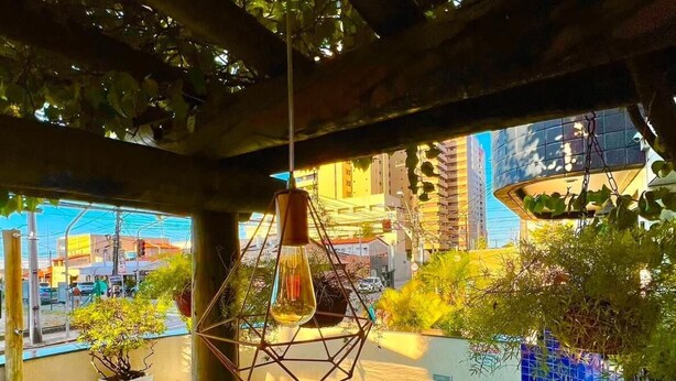 A rooftop pool area with a blue pool, a hanging light fixture, and potted plants. - Ara Mar Praia Hotel (Fortaleza)