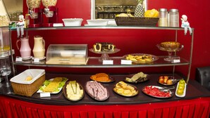 A buffet with various food items and a small figurine on the top shelf. - Ara Mar Praia Hotel (Fortaleza)