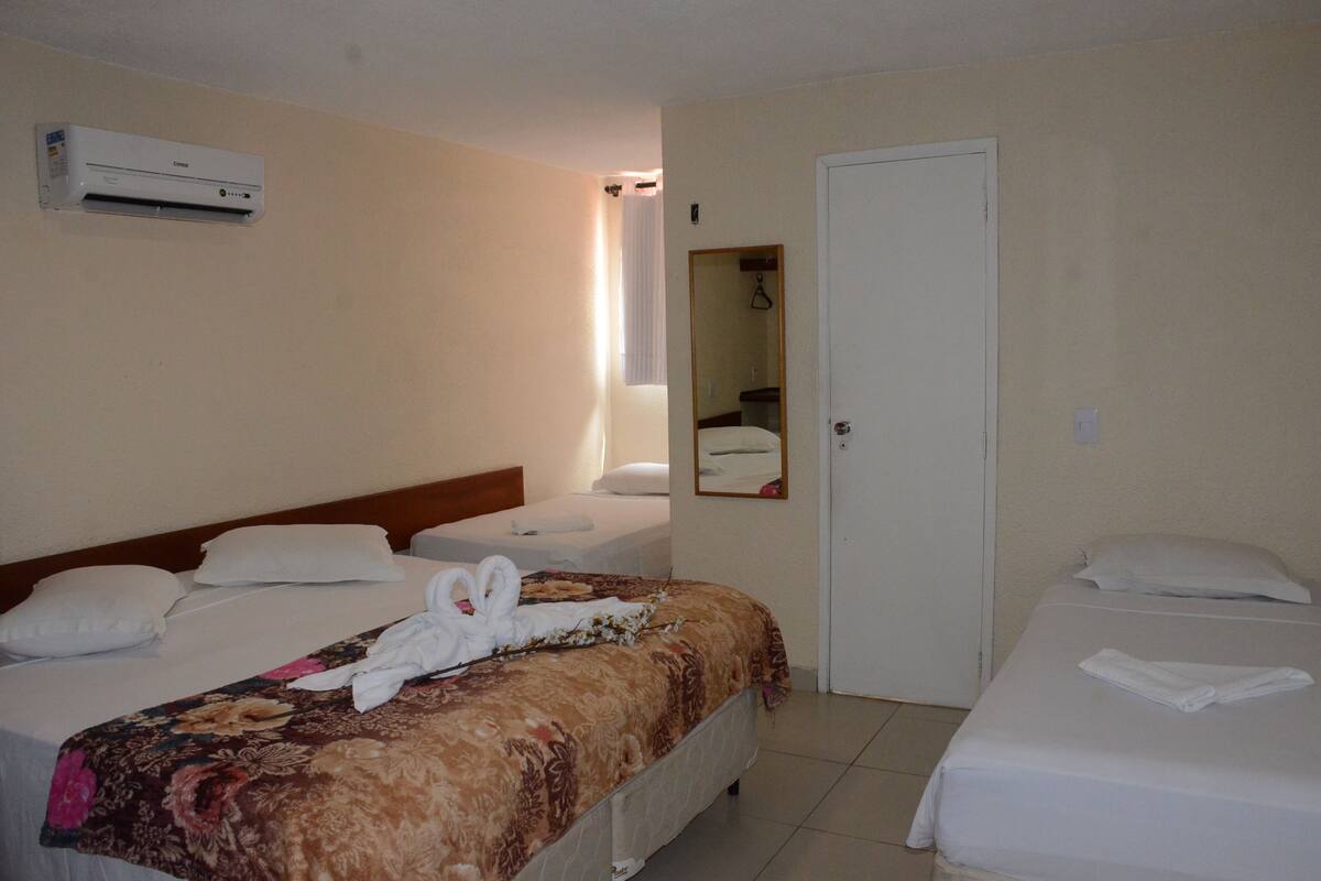 Ein Hotelzimmer mit zwei Betten, einem Badezimmer und einem Spiegel.