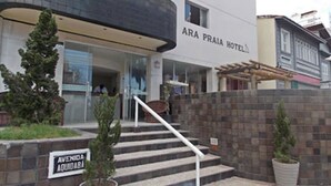 The exterior of the ARA PRAIA HOTEL with a staircase leading to the entrance, a sign indicating the street name, and a small garden area with potted plants. - Ara Mar Praia Hotel (Fortaleza)