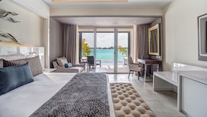 A modern hotel room with a large bed, a desk, and a view of the sea. - Grand Lido Negril Au-Naturel, An Autograph Collection All-Inclusive Resort - Adults Only (Negril)