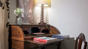 A wooden desk with a lamp, a vase with flowers, and books. - Buonanotte Garibaldi (Rome)