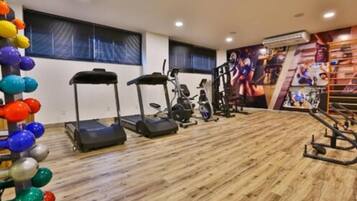 Et fitnesscenter med løbebånd, styrkemaskiner og en væg med sportsmotiver.