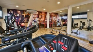 A gym with treadmills, stationary bikes, and a wall with fitness posters. - Arcus Hotel Aracaju by Atlantica (Aracaju)