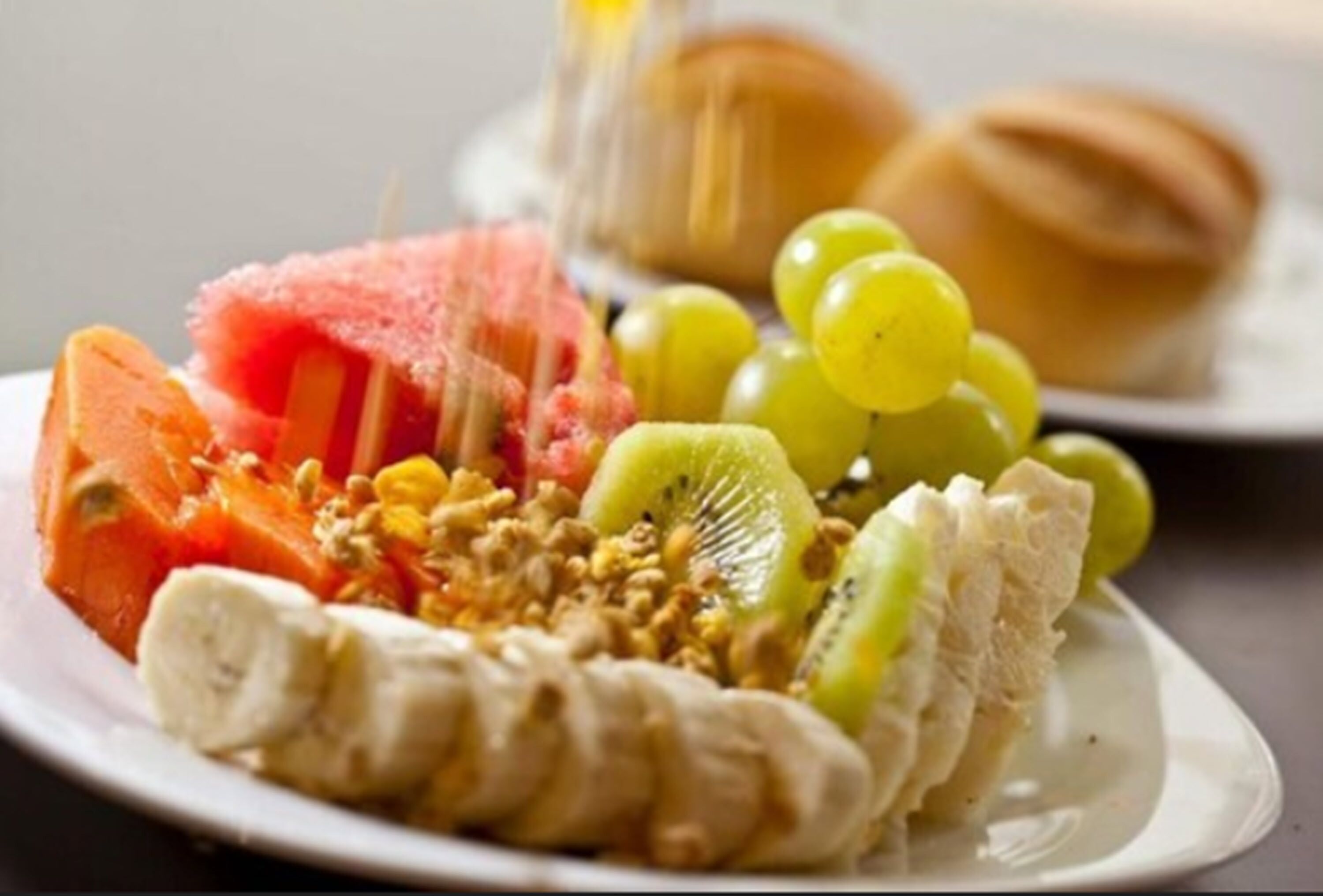 A plate with sliced fruits and granola.