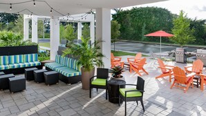 An outdoor patio with seating areas, a grill, and potted plants. - Home2 Suites by Hilton Ft. Lauderdale Airport-Cruise Port (Dania Beach)