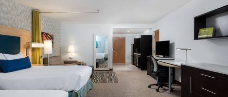 A hotel room with two beds, a desk, a TV, and a wardrobe.