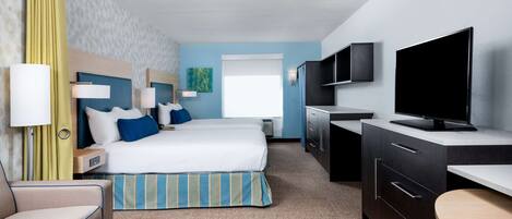 A hotel room with a bed, bedside tables, a TV, a desk, and a chair.