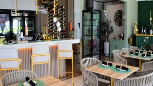 A restaurant with a bar area, multiple dining tables with chairs, and a kitchen in the background. - Luichy's Seaside Hotel (Cabo Rojo)