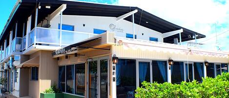 A modern building with a storefront labeled 'Marina's,' large windows, and a covered outdoor area.