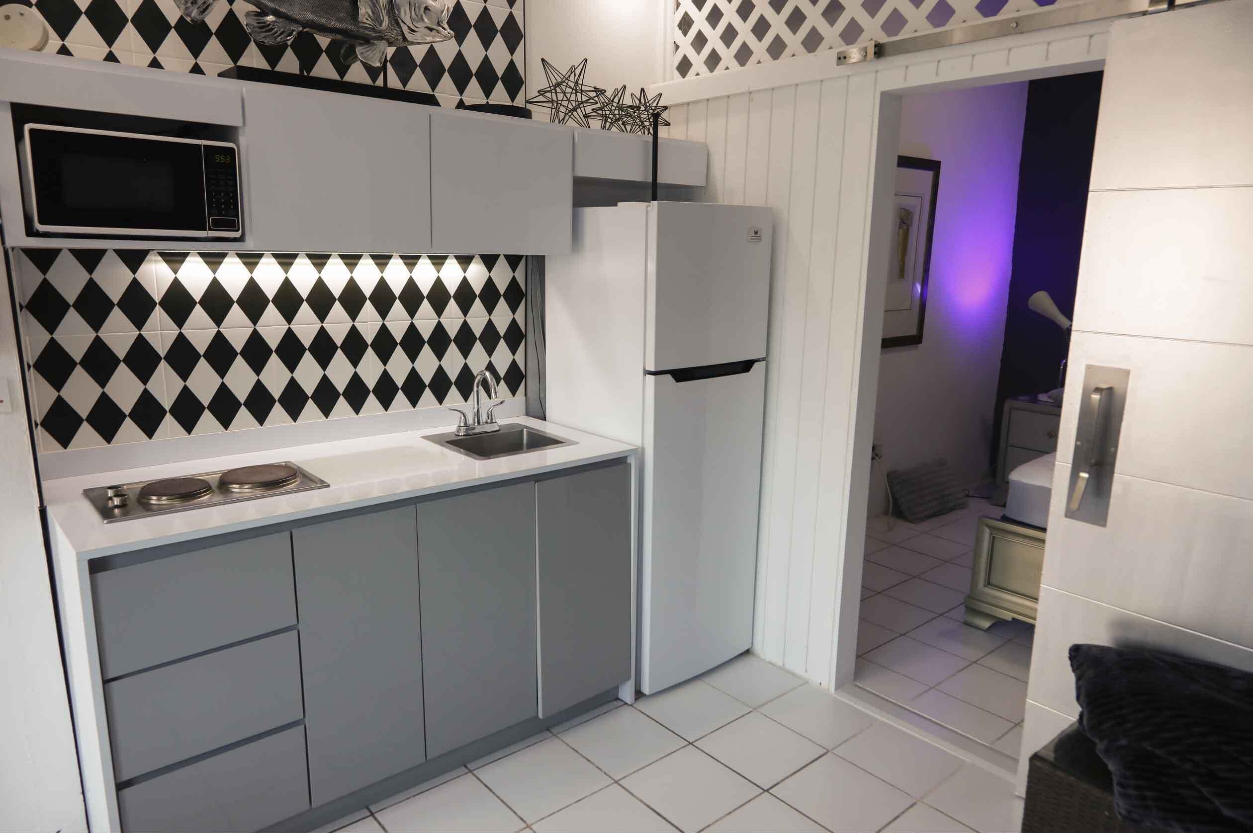 Una cocina moderna con microondas, lavamanos y refrigerador.